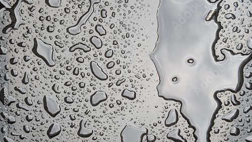 Photos Water droplets and reflective puddles creating an abstract, textured surface on