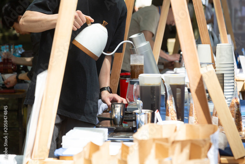 Tableau sur toile 屋外のコーヒースタンドでコーヒー粉にお湯を注ぐ男性の手元