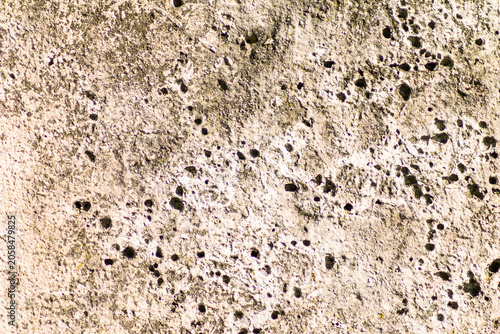 Fotografía Weathered stone wall blocks with lichen stains and rough texture material closeu