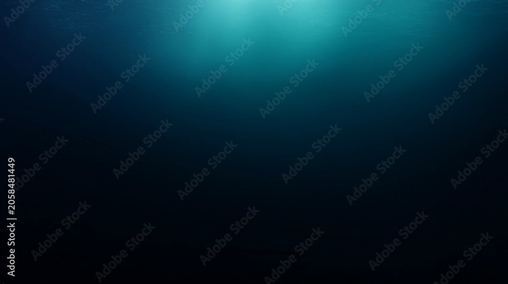 Obraz premium Deep blue ocean water background, abstract underwater background with light rays shining through the surface