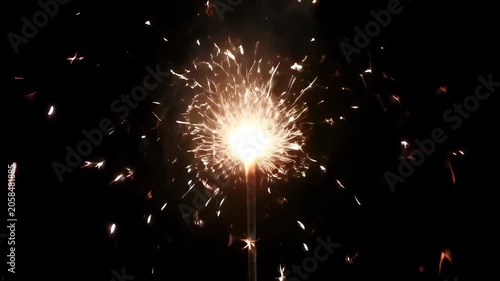 Sparkler firework bright light in dark night celebration background with festive burst glow and black sky party scene