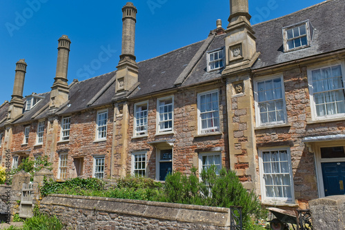 Tableau sur toile A picturesque row of historic stone houses featuring tall chimneys and numerous