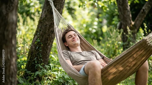 Relaxing Hammock Man in Green Forest Nature, Under Trees, Peaceful Outdoor Leisure with Soft Sunlight