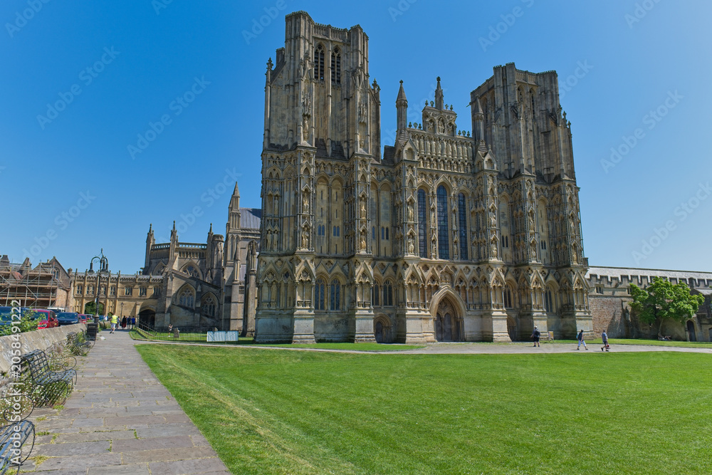 Obraz premium A grand Gothic cathedral with two tall towers stands against a bright blue sky - Wells Cathedral - Wells - Somerset - UK