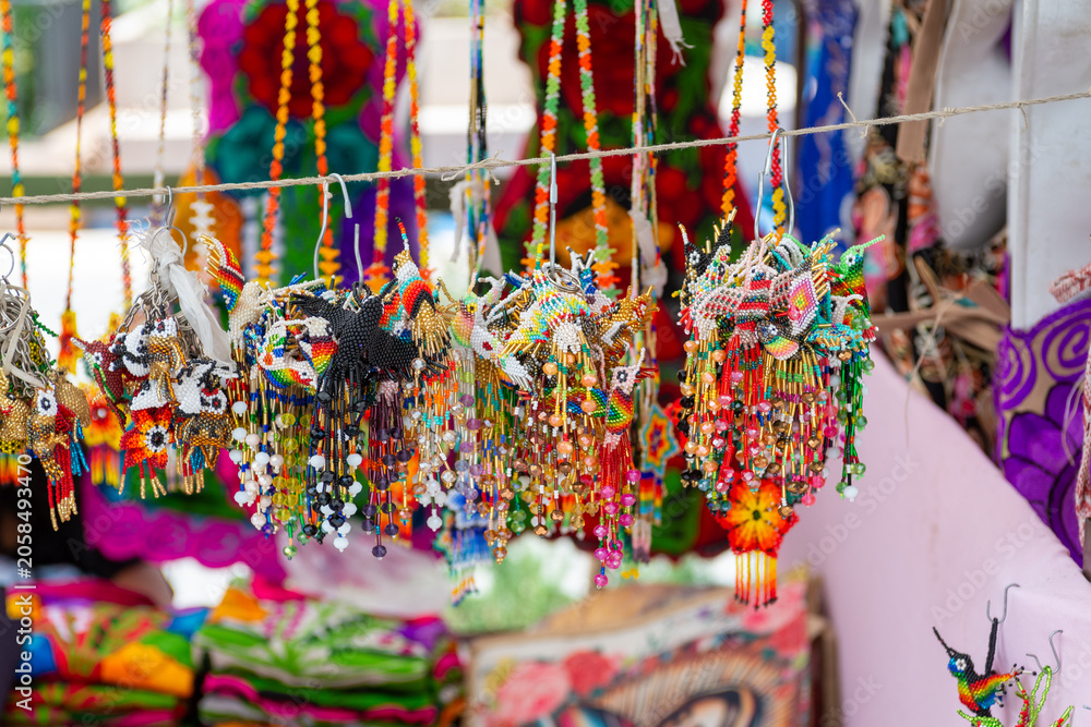 Obraz premium Colorful Huichol Beaded Hummingbird Ornaments Displayed at a Mexican Artisan Market