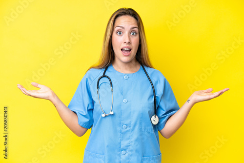 Young surgeon nurse woman isolated on yellow background with shocked facial expression