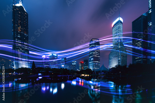 Futuristic smart city with digital data light trails at night.