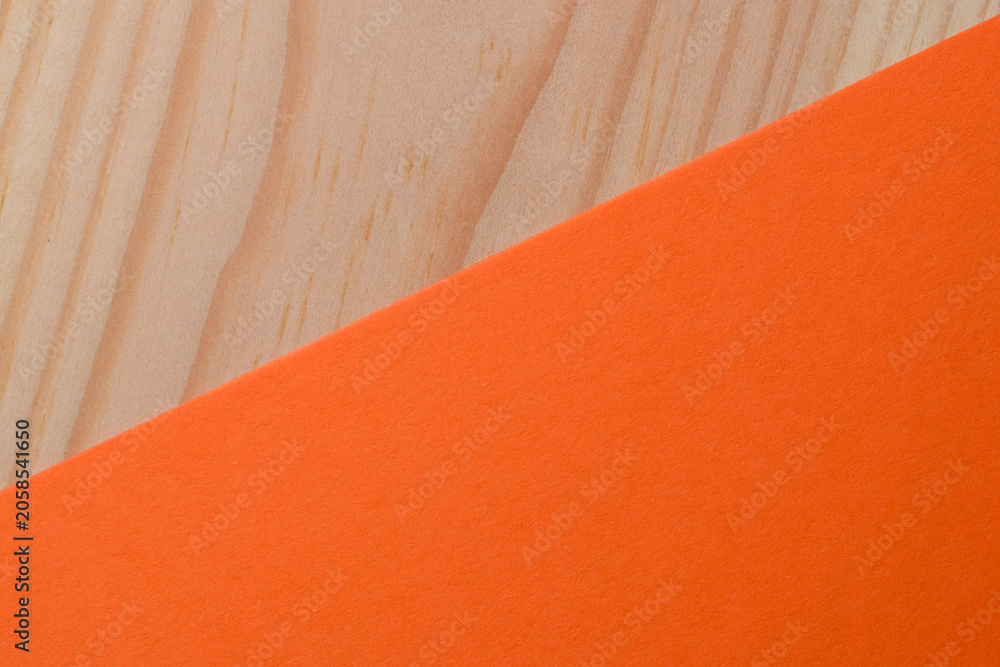 Fototapeta premium Bright orange paper contrasts with light wooden surface beautifully