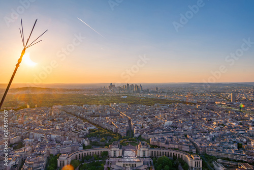 Partial solar eclipse on the horizon over the Paris cityscape with the Trocadero and the La Défense financial district at sunset as seen from the Eiffel Tower.