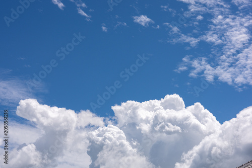 A photograph of the sky on a clear day shows clouds up close with distinct curves.