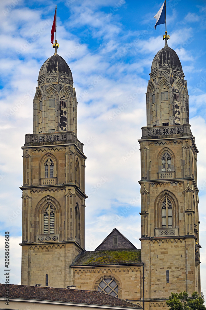 Fototapeta premium Grossmunster Church Twin Towers and Facade with Flags in Zurich Switzerland