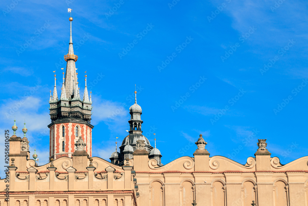 Obraz premium Gothic spires and ornate facade of historic European town hall against blue sky