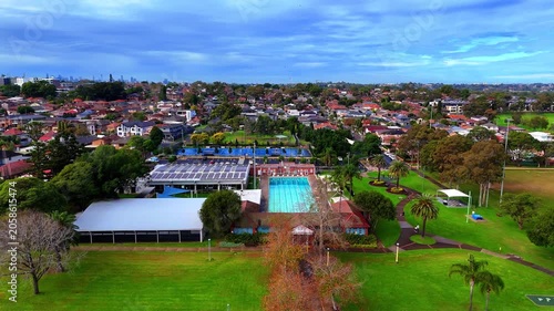 Drone panoramic aerial view of Sydney NSW Australia city Skyline and looking down on all suburban houses and streets of western Sydney of Burwood and Enfield