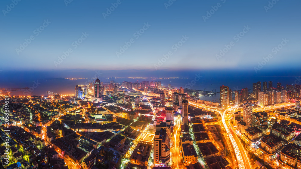 Fototapeta premium Night View Of Coastal Urban City With Illuminated Buildings And Roads