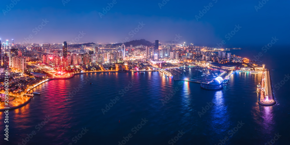 Obraz premium Nighttime Coastal Cityscape With Marina And Illuminated Buildings