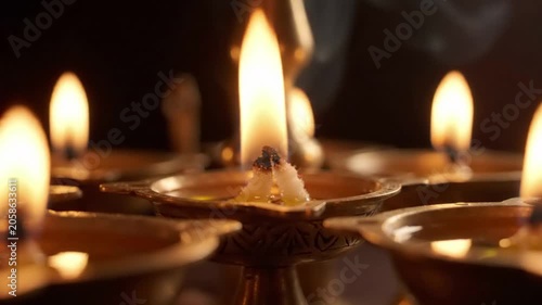 Close Up Of Traditional Brass Oil Lamps With Glowing Flames In Dark Setting For Religious Ceremony