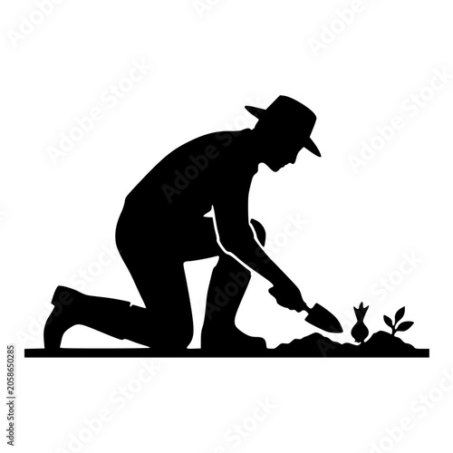 Gardener silhouette kneeling with trowel planting bulb in soil