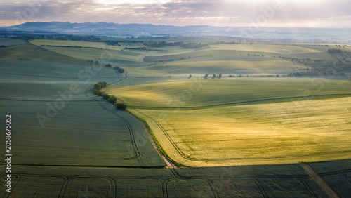 sunrise over rolling spring hills bathed in golden light and morning mist
