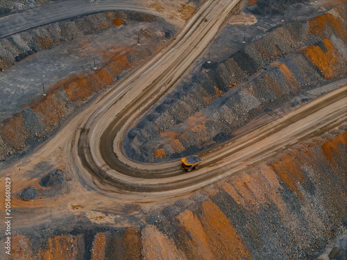 Tableau sur toile Mining haul truck navigating curved road in open pit quarry, gold mining industr