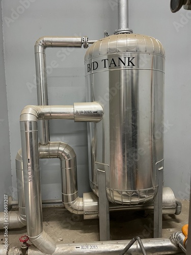 Steam utility equipment and distribution pipelines inside a food manufacturing facility. Industrial infrastructure supporting process heating, steam generation, and production operations.