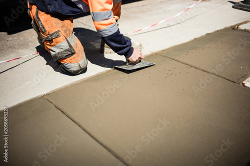 Картината върху платно concrete worker levelling concrete and troweling the concrete smooth on a indust