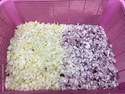 Fresh chopped onion and shallot prepared in a food-grade basket before food manufacturing operations. Ingredient preparation stage supporting large-scale food production, recipe formulation, and comme