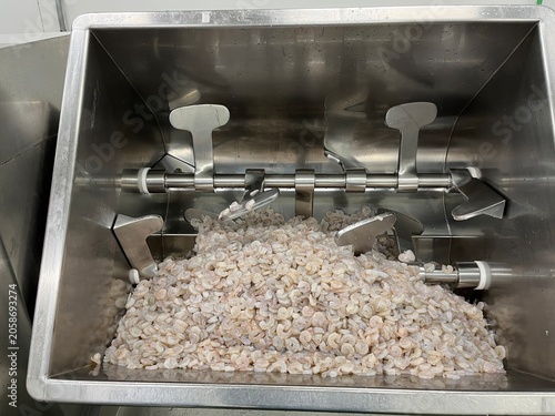 Foto Stainless steel industrial food mixer with paddle agitators mixing minced ingredients during food production