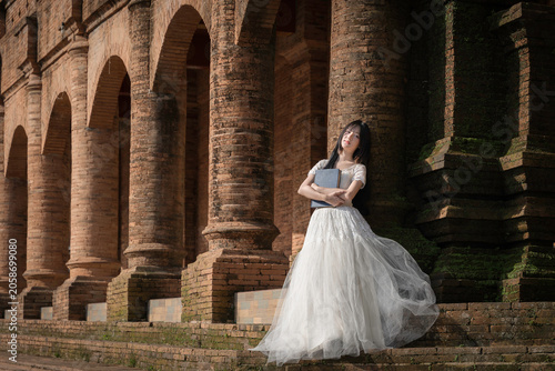 Portrait Fashion Asian Woman in White Gown at Ancient Brick Temple Architecture in Chiang Mai Thailand