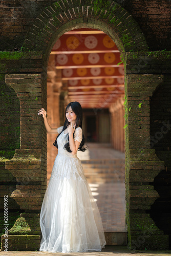 Portrait Fashion Asian Woman in White Gown at Ancient Brick Temple Architecture in Chiang Mai Thailand