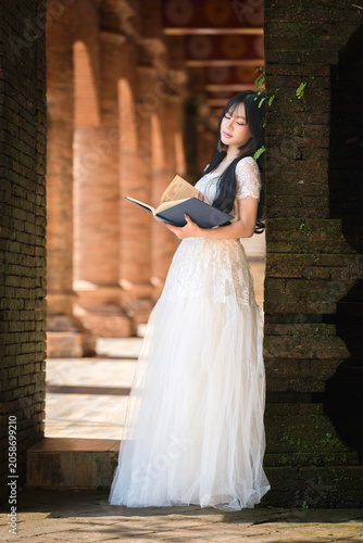 Portrait Fashion Asian Woman in White Gown at Ancient Brick Temple Architecture in Chiang Mai Thailand