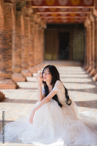 Portrait Fashion Asian Woman in White Gown at Ancient Brick Temple Architecture in Chiang Mai Thailand