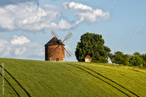 Historic Chvalkovice windmill in a vibrant spring landscape with green field