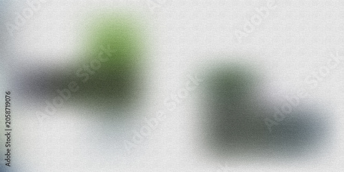 Two blurred geometric shapes in green and grey tones on textured white background