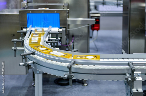 Industrial x-ray inspection system scanning food product packages on curved conveyor belt