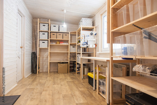 Tool storage room, workshop in a wooden house. Storage racks and boxes