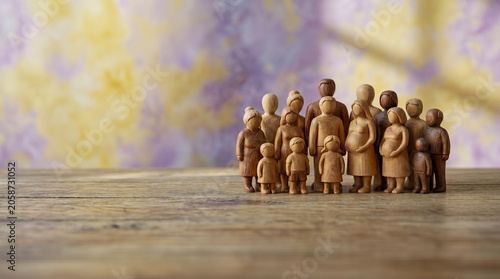 Obraz na plátně Diverse group of wooden figurines symbolizing World Population Day, representing global demographics, family unity, pregnant mothers, and human development on a rustic surface