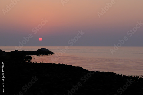 Fishermen silhouetted against a sunset in Goa, India 