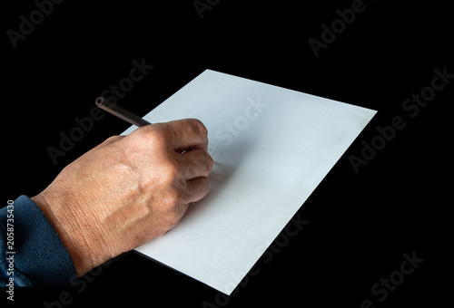 A hand with a pencil on a piece of white blank paper. Image with copy space.
