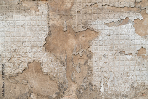 Cuadro en lienzo Weathered wall texture with exposed tile pattern and deteriorated plaster