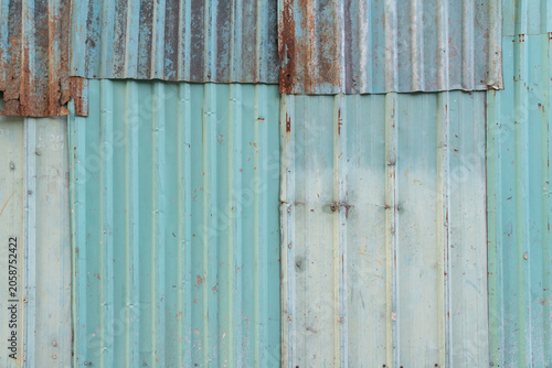 Weathered corrugated metal wall texture with rust and faded paint