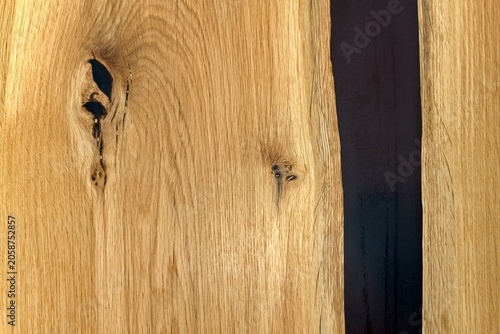 Detail of modern luxury table made of oak and epoxy, surface treated with wax. Handmade wooden table and black epoxy resin, flat lay.