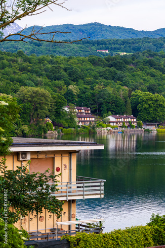 Villas on the shores of the Lago Grande di Avigliana surrounded by Alpine mountains at sunrise, Avigliana Nature Park, Susa Valley