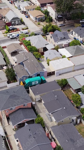 Aerial top down inspection of a low income neighborhood with small homes, trees, cars and streets in south central Los Angeles, California