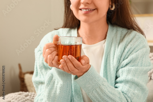 Smiling woman holding warm ...