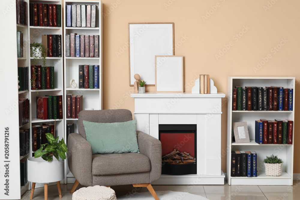 Obraz premium Cozy home interior with fireplace, armchair, and bookshelves, modern living room decor and reading nook