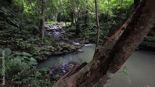 The video background features a natural landscape of a waterfall in a lush forest. Sam Lan Waterfall in Saraburi National Park boasts beautiful flowing water surrounded by diverse flora.