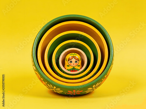 Russian Matryoshka nesting doll isolated on yellow