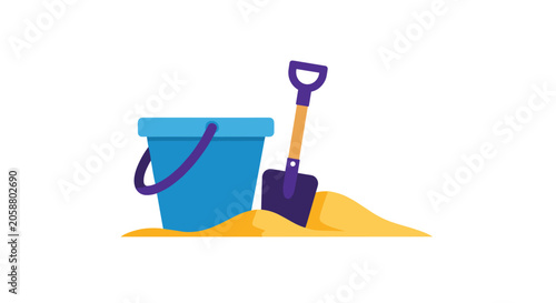 Blue beach bucket and purple spade sitting in a pile of golden sand for a summer vacation and creative outdoor play.