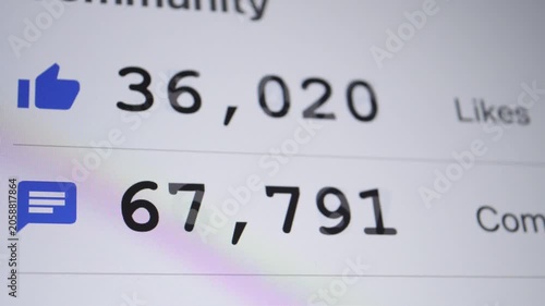 A close-up shot of social media metrics displaying high counts of likes and comments with blue icons on a screen.
