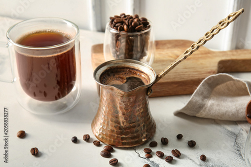Cup and cezve with hot brew...